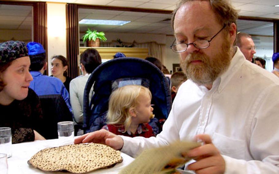 Allen Kent reads the Haggadah prayer book during a Passover Seder on Wednesday at the 8th Army Religious Retreat Center in Seoul. Kent, his wife, Tobe Pilato, and son, Avi, 2, came to South Korea from Yokosuka Naval Base, Japan, for the occasion.