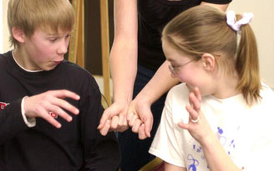 Jill Franklin, center, of the Missoula Children’s Theatre, rehearses a scene from “Hansel and Gretel” on Tuesday in Landstuhl, Germany, with Scott Cox, 12, and Anne Briggs, 13. The Missoula Children’s Theatre is touring U.S. military bases in Europe, helping youth put on a play in less than a week.