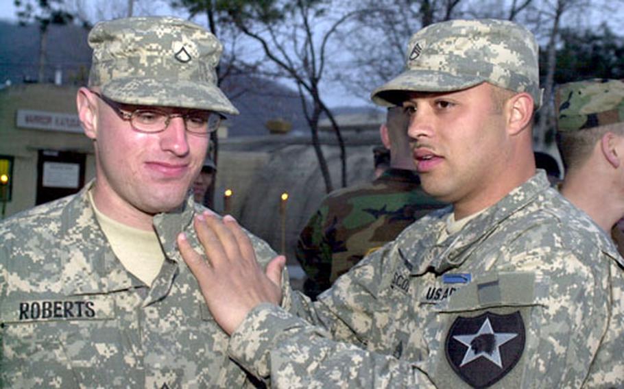 Pfc. Bradley Roberts of 2nd Infantry Division’s 1st Battalion, 72nd Armor Regiment, receives his Expert Infantryman’s Badge from Staff Sgt. Christopher Scott at a Camp Casey ceremony on Thursday. After testing earlier this week, 209 soldiers from all over South Korea received the prized badge.