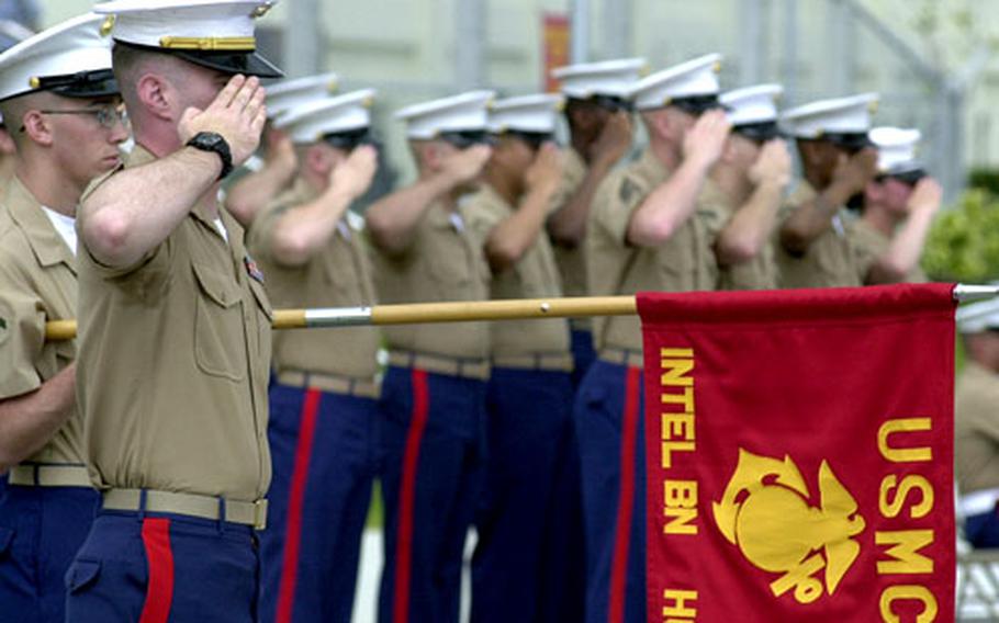 Marines from 3rd Intelligence Battalion salute in formation during a building dedication Friday on Camp Hansen. The unit’s newest building, “Courtney Hall,” was dedicated to the only Marine from the battalion to be killed in Iraq — Sgt. Kelley L. Courtney.