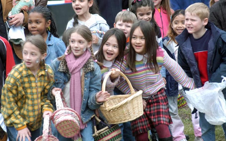 Girls and boys ranging in age from 6 to 8 years old get ready Saturday to charge a pile of hay concealing gifts from the Easter bunny, by way of his American associates stationed in Hanau, Germany.