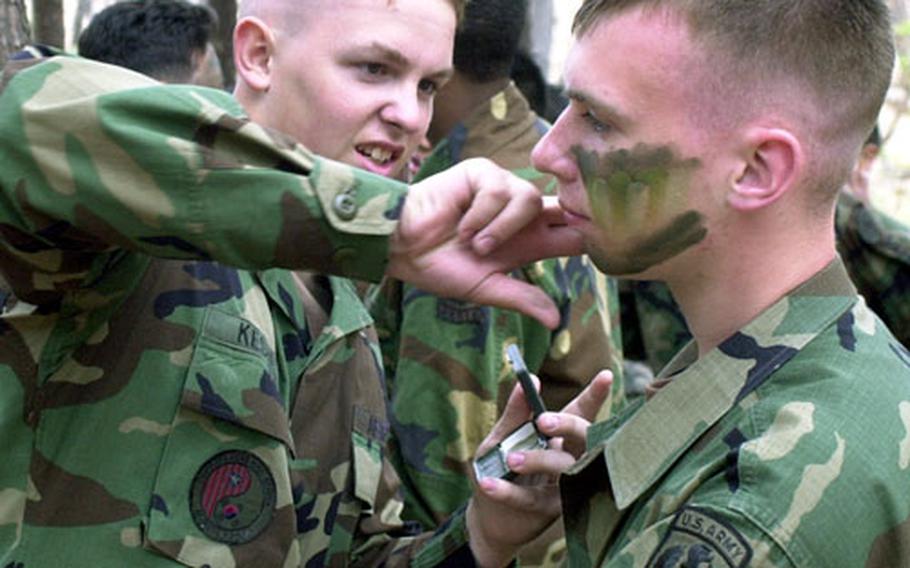 Osan American High School student Donald Keshel, left, applies camouflage makeup to Seoul American High student Joseph Wisniewski during Junior Reserve Officer Training Corps training at Camp Jackson Thursday. The 33 students from all over the peninsula spent their Spring Break week learning soldiering skills.