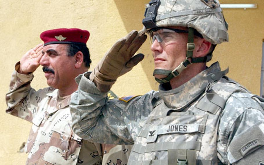 Col. Shojaa, commander of 1st Brigade, 4th Iraqi Army Division, and Col. Brian D. Jones, commander, 3rd Heavy Brigade Combat Team, 4th Infantry Division, salute during a transfer of authority ceremony at an Iraqi army base near Balad, Iraq.