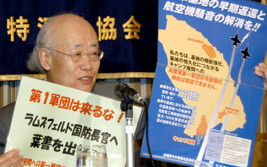 Takio Izawa, chair of a citizens group near Camp Zama opposed to realignment plans, speaks to reporters Monday during a press conference. He is holding signs local residents created to oppose U.S. force structure plans.
