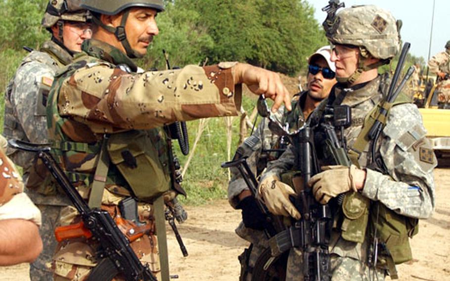 Capt. Matthew Jensen talks to Maj. Anwar of the Iraqi army during a patrol into an insurgent sanctuary near Muqdadiyah.