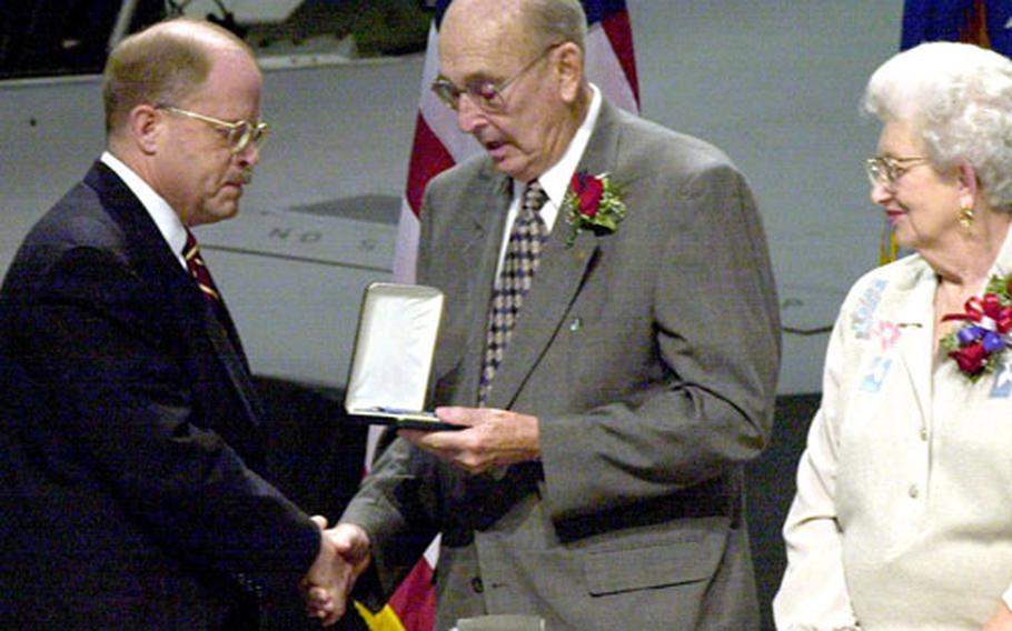 William F. Pitsenbarger, center, accepts the Medal of Honor on his son's behalf from Secretary of the Air Force Whit Peters, during a ceremony at Wright-Patterson Air Force Base, Ohio. At right is Pitsenbarger's wife, Alice.