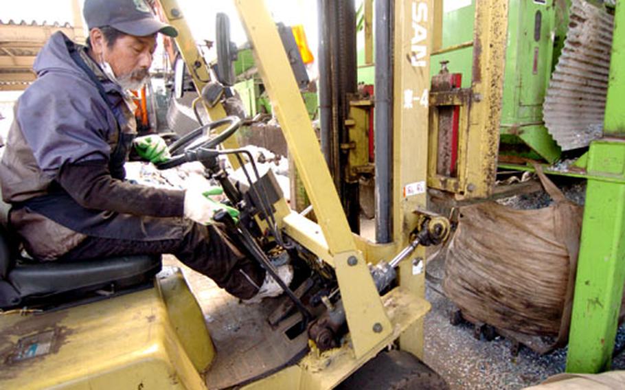 A Japanese worker compacts garbage Friday at the Recycling and Incinerator Plant on Yokota Air Base, Japan. In 2005, the facility handled more than 9,000 tons of waste generated by base servicemembers, civilians and their families.