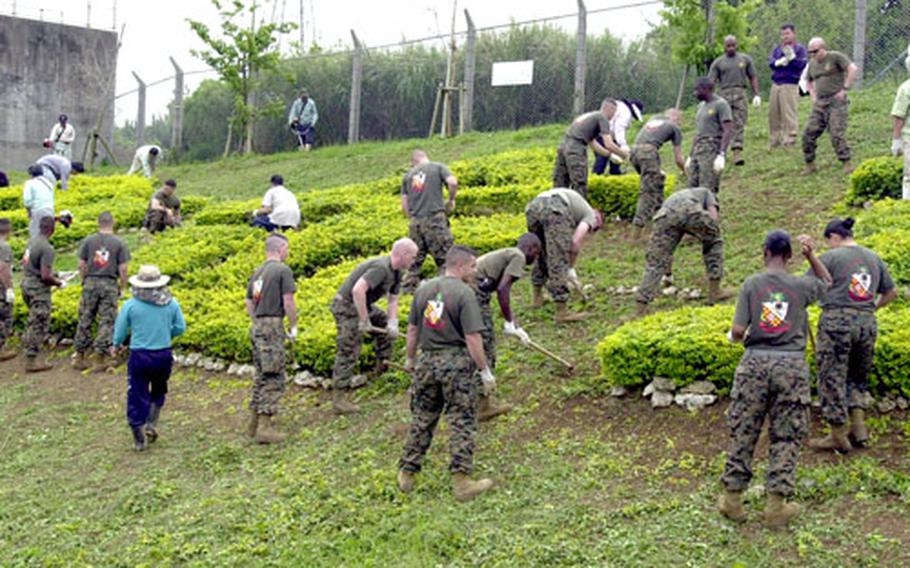 Marines from 3rd Intelligence Battalion team with local business leaders on Thursday to clean up a portion of Highway 104, which runs by Camp Hansen, Okinawa.