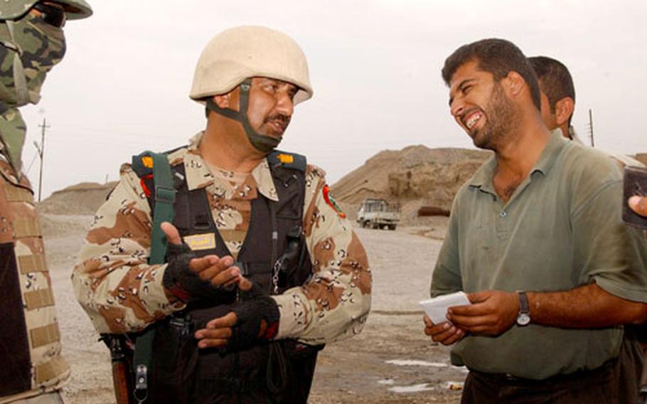 Iraqi Maj. Saleh talks to a local man about two weapons found by Iraqi and U.S. troops during a search.