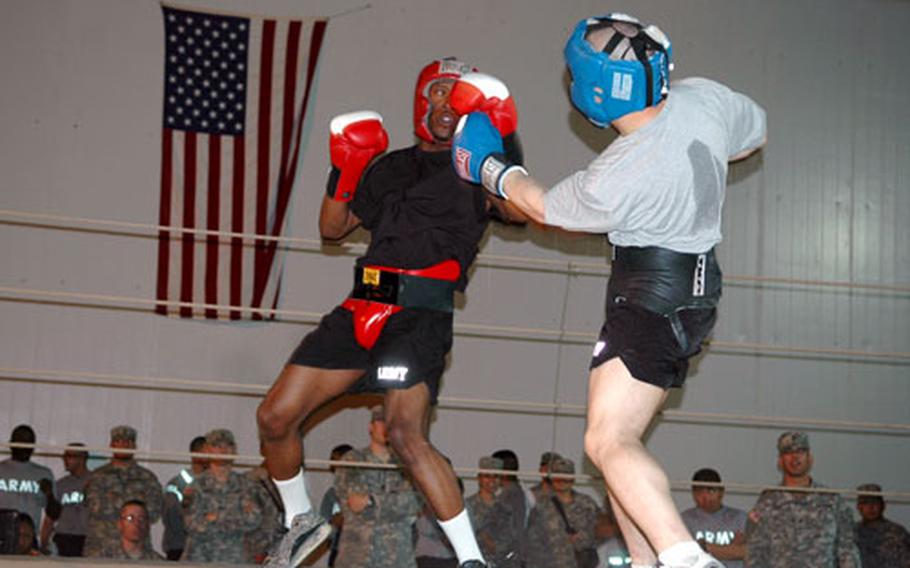 Spc. Keeon Britton, left, blocks a punch thrown by Sgt. Domenico Carbone on Friday during the 1st Brigade, 1st Armored Division boxing championship at Forward Operating Base Sykes, in northeast Iraq.