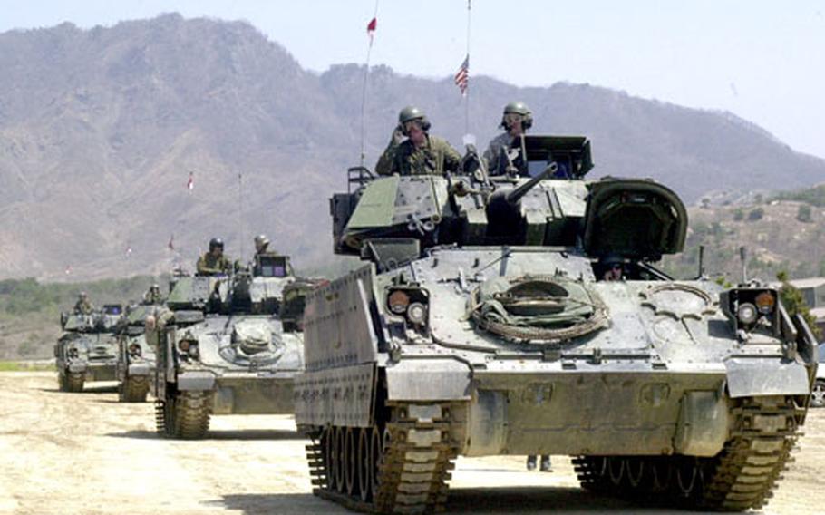 Soldiers from the 2nd InfantryDivision’s 4thSquadron, 7th Cavalry roll through Rodriguez Range in their BradleyFighting Vehicles after firing in tandem during training Friday. The soldiers fired at targets up to 1,800 meters away and were joined by Air Force A-10 aircraft support.