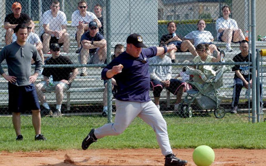 Jason Cohick, with part of a hot dog in one hand, takes a kick Monday during one of the events at a sports day at Aviano Air Base, Italy, on Monday.