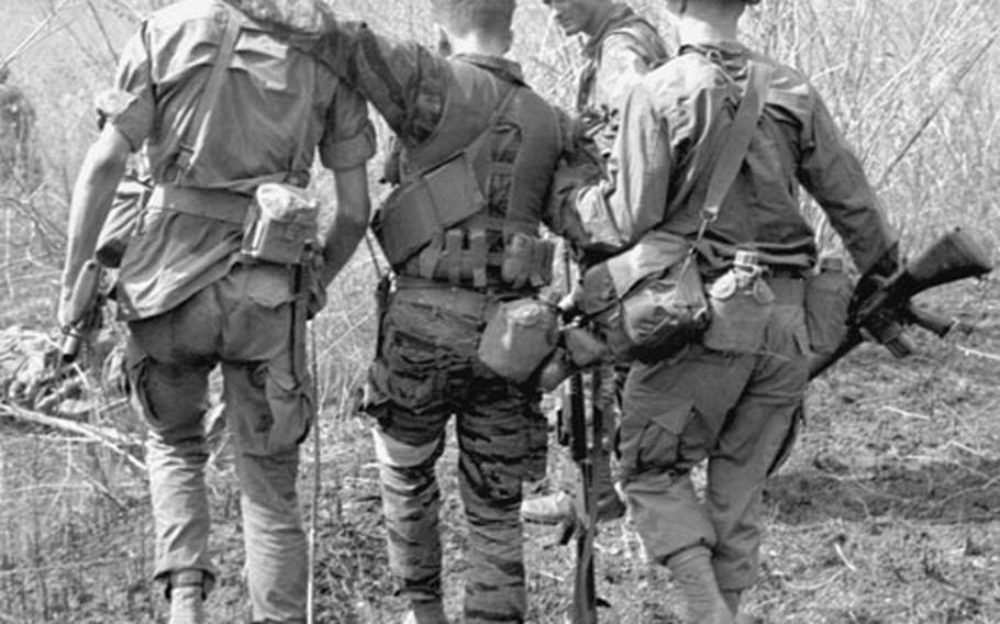 During an April, 1968 mission to recover the body of a fallen comrade in Vietnam, soldiers take cover from snipers, watch over a wounded Viet Cong, and help a fellow soldier back to a helicopter.