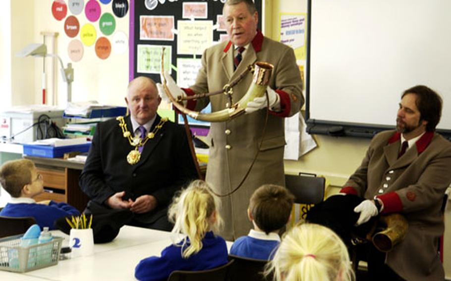 George Pickles, the Ripon horn blower, shows the instrument he uses in his ceremonial watchman's duties to students at Moorside Juniors School in Ripon last month, as Ripon mayor Stewart Martin, left, and American deputy horn blower Eugene "Geno" Boarman, right, look on.