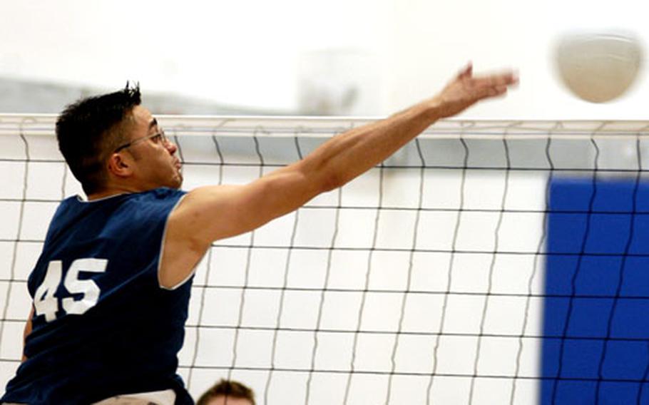 Staff Sgt. Josh Begay of the 48th Civil Engineering Squadron spikes a volleyball past defenders from the 48th Munitions Squadron.