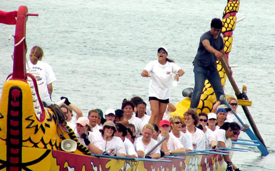 Irene Gilliand, standing, coach of the U.S. Army Women's Dragon Boat Team, guides her team's boat during a pratice his past weekend at Tomari Port. Gilliand, 41, is a substitute teacher for DODDS on Okinawa and has coached the team for the past three years.