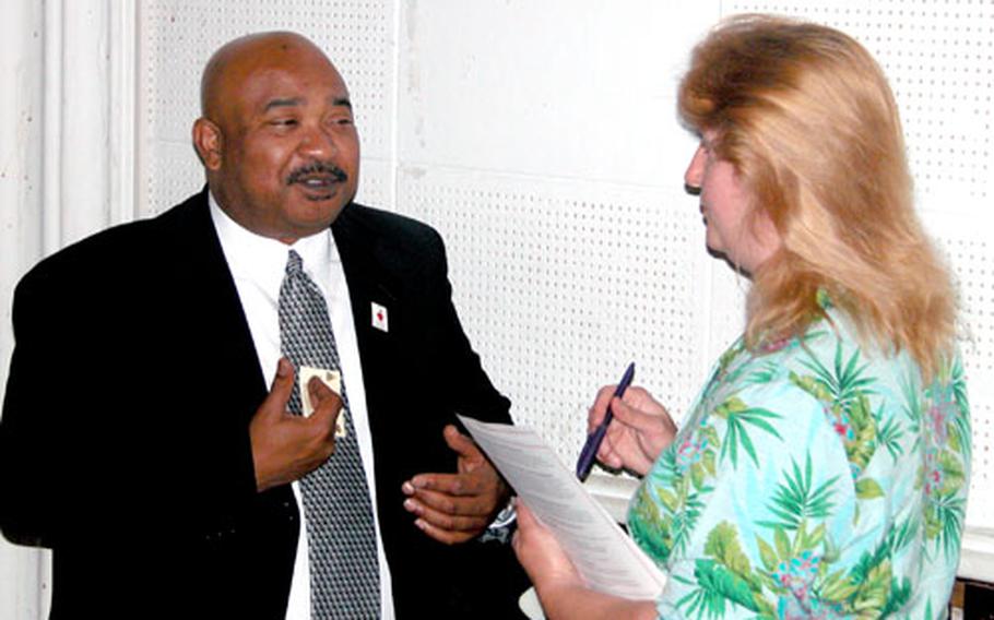 Ron Walker, left, superintendent of the Geary County (Kansas) School District, speaks with Sandra Dossett, wife of Master Sgt. Edward Dossett of the 1st Armored Division’s 4th Brigade, during a forum Friday in Hanau.