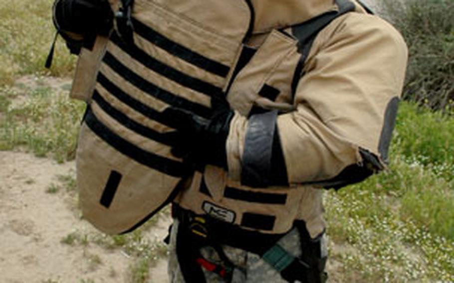 A soldier dons his Cupola Protective Ensemble recently in Mosul, Iraq. Soldiers said they thought the suits looked “goofy” although they provided added protection against roadside bombs.