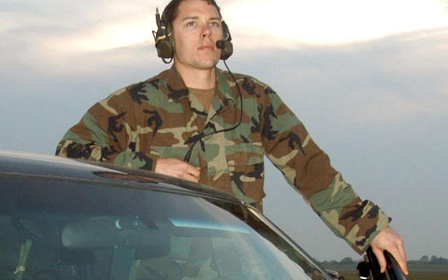 Airman 1st Class Charles Fraser monitors radio traffic minutes before the jump.
