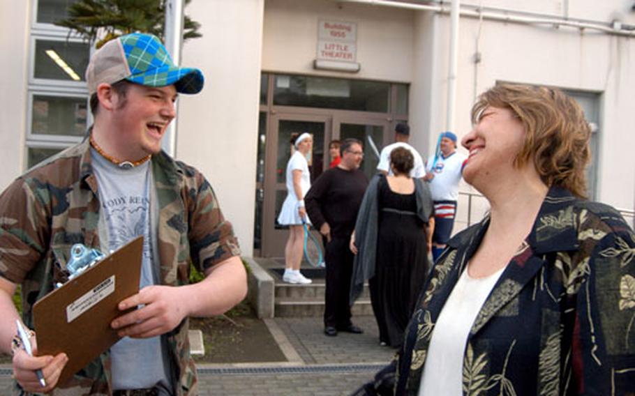 “California Suite” volunteer Chris Woody laughs with actress Nancy Kelley-Burne as they get the prop list together outside of the Little Theater Yokosuka Naval Base in Japan.