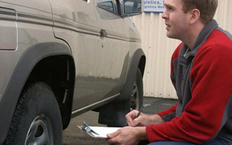 Orvar Kristjansson checks out one of the SUVs the vehicle processing center is sending out of the country as the U.S. military population pulls out. In a normal month, the center used to send about 15 vehicles per boatload, but recently it has been sending about 85 at at time, he said.