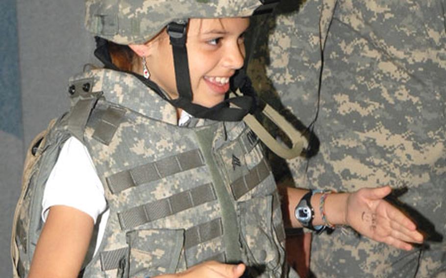 Kelly Villwock, a 10-year-old fifth-grader at Schweinfurt Elementary, tries on a helmet and body armor Thursday during the deployment training event.