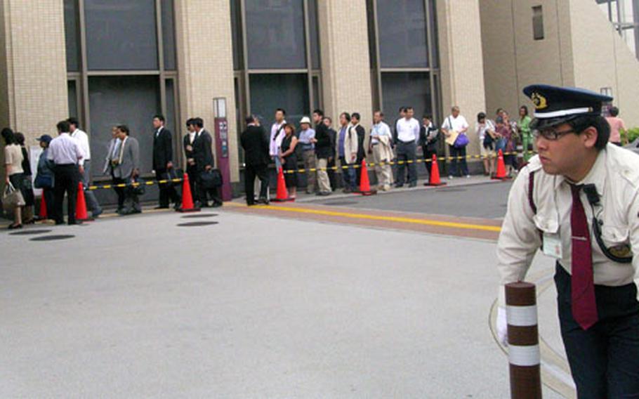 A guard stands outside Yokohama District Court on Friday as people line up for the sentencing of U.S. Navy airman William Oliver Reese Jr. Reese, 22, received life imprisonment for murdering a Japanese woman during a robbery.