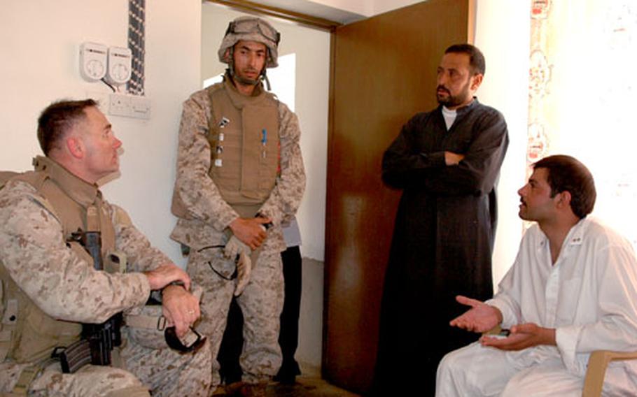 Lt. Col. Norman Cooling, left, meets with local men in Haditha, where he often reminds locals that his unit is not the one under investigation for killing civilians last year.