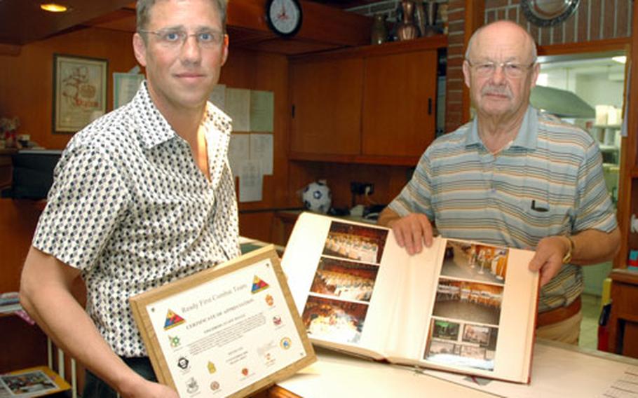 Ralf Mackenrodt and Werner Wissel, manager and owner, respectively, of the Friedberg Hotel and Restaurant, show one of their many albums full of American military banquets held at their locale.