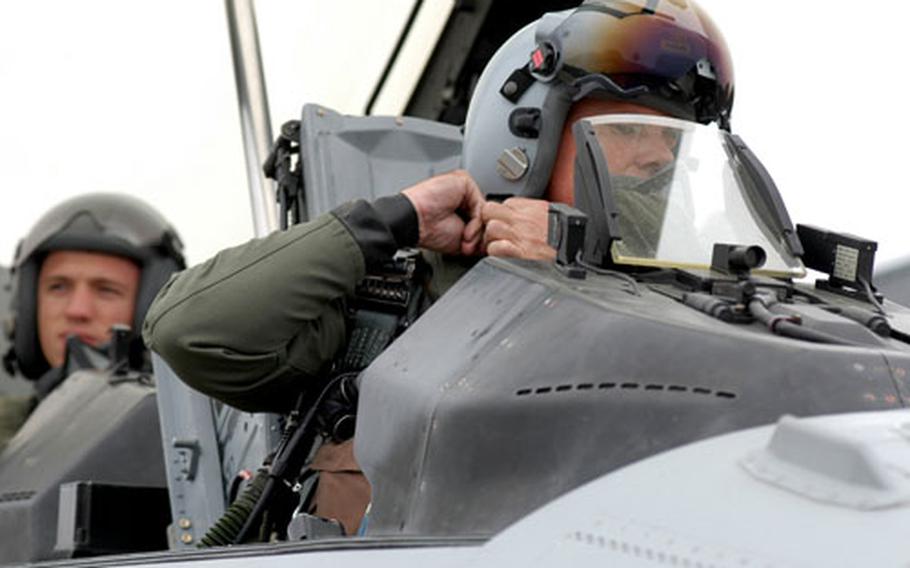 35th Fighter Wing Commander Brig. Gen. Sam Angelella adjusts his helmet prior to taking U.S. Air Force Academy senior Scott Kumpula, back seat, on his first ride in an F-16.