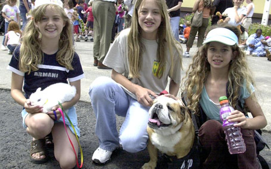 The Anderson sisters: Taylor, 10, Jordan, 12, and Kelsey, 8 show off their rabbit, Hasempfeffer, and English bulldog, Diamond, at a Pet Parade organized by the Grafenwöhr Library on Thursday.