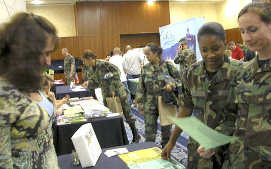 Chriss Lavigne, left, talks with Staff Sgts. Ebony Clark and Mary Sharp during the “Explore the Eifel” fair.