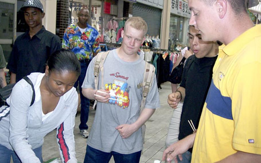 2nd Infantry Division soldiers try some local dumplings and rice balls at a market on Friday in Dongducheon. Experts with the 18th Medical Command are warning the U.S. military community to be especially careful eating and drinking off base as the largest food-borne illness outbreak in Korean history races across the peninsula.