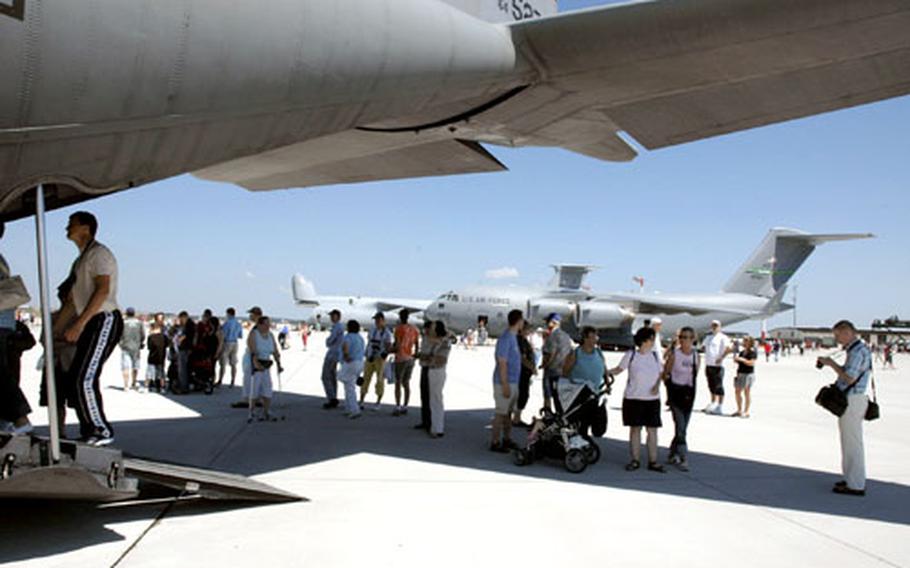 The shadow of the tail of a C-130 plane offers spectators some protection from the blazing sun as temperatures reached in the high 80s at Saturday’s open house event at Spangdahlem Air Base, Germany.