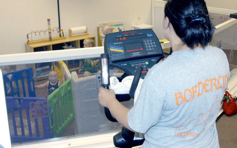 Julie Ooten, whose husband is deployed, watches her two children while working out on an elliptical machine Saturday at the Samurai Fitness Center on Yokota Air Base, Japan.