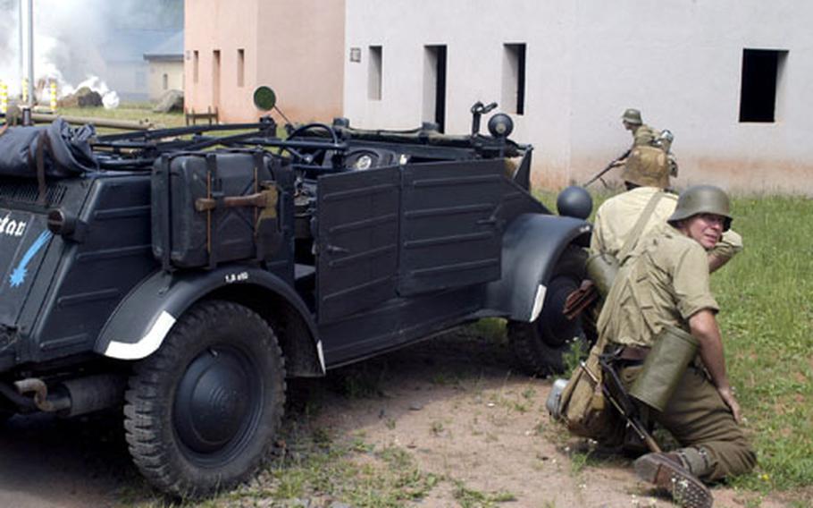 At a World War II re-enactment in Baumholder, Germany, on Saturday, German troops take cover behind a Kugelwagen as simulated artillery pounds Allied positions.