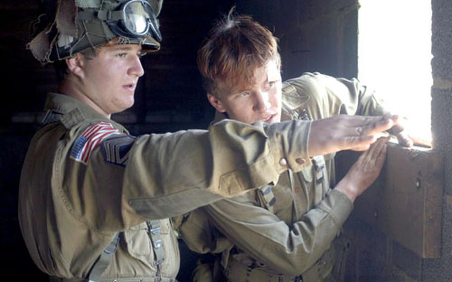 Ignacio Suarez, left, and Thomas Richardson Jr., both 15, look out over the battlefield at a World War II re-enactment in Baumholder, Germany, on Saturday.