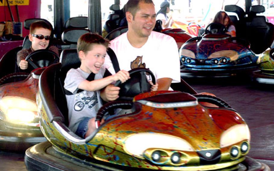 Tech. Sgt. John Wright, an F-15C crew chief for the 48th Aircraft Maintenance Squadron, and his son, Jared, 7, both man the steering wheel of a bumper car during the Fourth of July celebration at RAF Feltwell.
