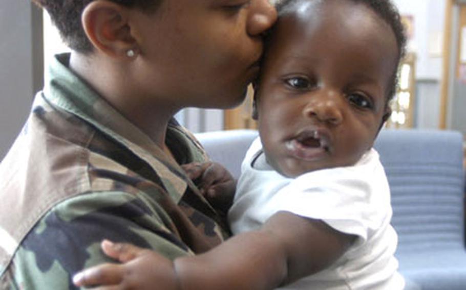 Senior Airman Samantha Bryant, an aerospace medical service technician with the 48th Medical Operations Squadron, kisses her 5-month-old son, Norsean. Bryant and her son escaped uninjured after her home at RAF Lakenheath caught fire on June 22.