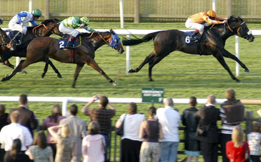 Red Cape, right, and his jockey race toward the finish line in the Class 3 Handicap Stakes during the first Newmarket Nights event of the summer.