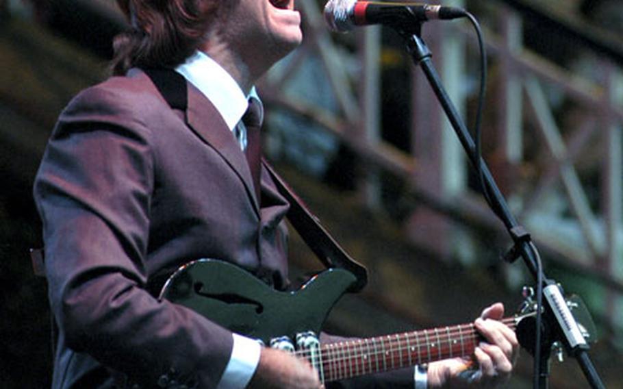 Portraying John Lennon, a guitarist for the Bootleg Beatles sings during the first Newmarket Nights event of the summer.