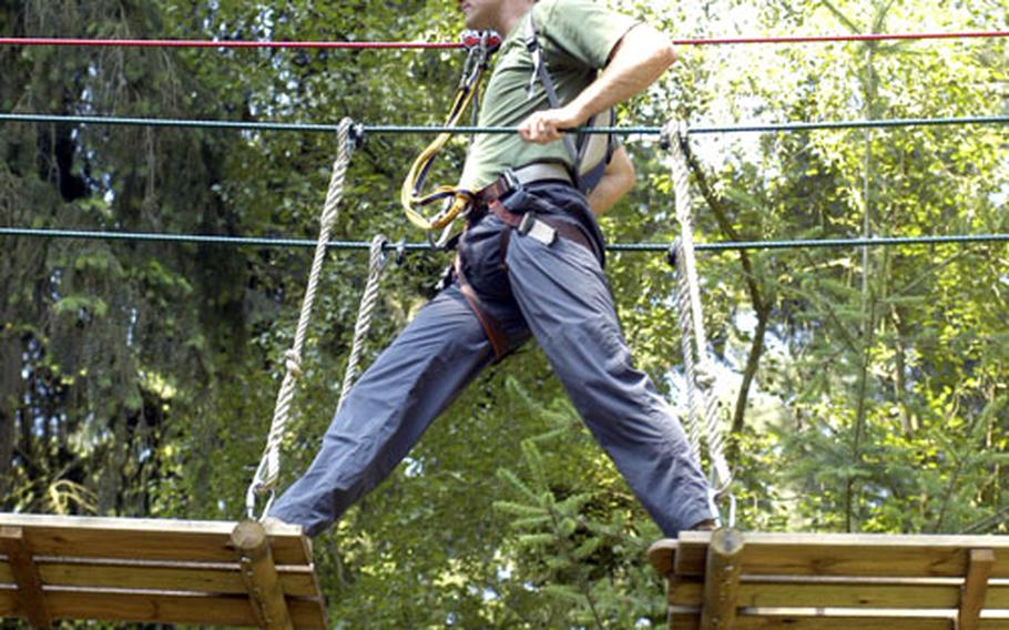 Julian Dormady crosses the half steppingstones bridge, which is one of 36 obstacles that the Go Ape high-wire forest adventure offers to its customers.