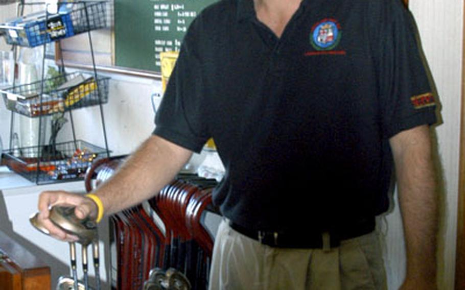 Breckland Pines employee Steve Pavick holds a rental set of golf clubs.