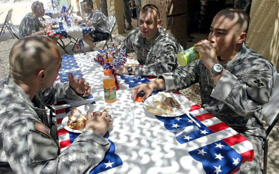 First Battalion, 8th Infantry Regiment soldiers at Forward Operating Base Paliwoda tuck into their Fourth of July meal.