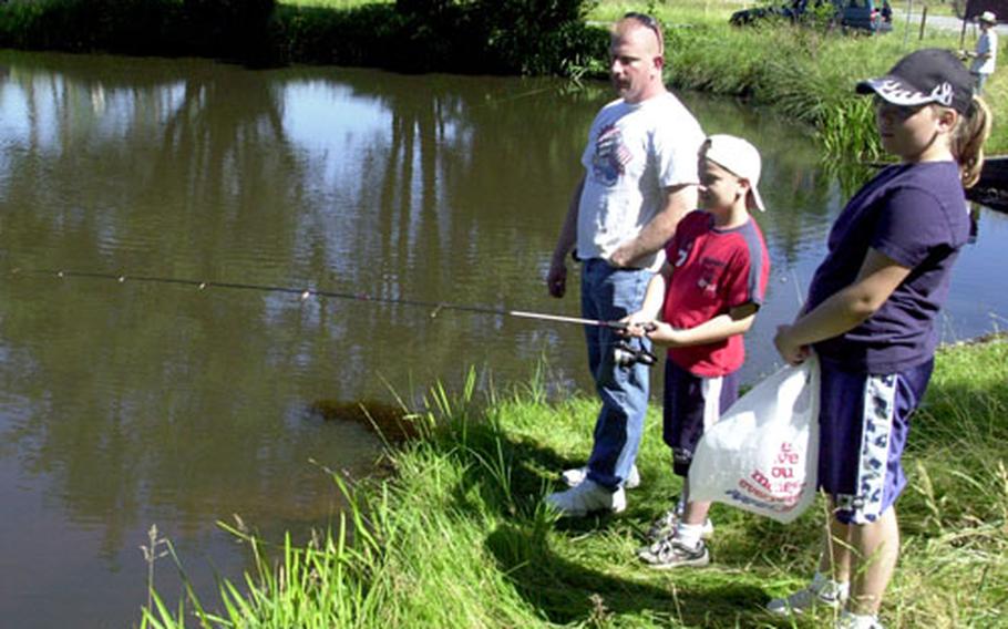 Sgt. 1st Class Edward Bogawitch, 37, of Fulton, N.Y., and his children — Kenneth, 8, and Sharon, 12 — participate in a July Fourth fishing contest at Grafenwöhr, Germany.
