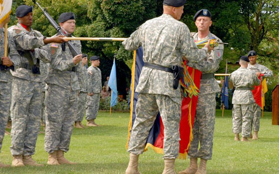 Maj. Gen. Kenneth W. Hunzeker, back to camera, and Command Sgt. Maj. John D. Fourhman, commander and sergeant major of 1st Infantry Division, case their unit’s colors during a farewell ceremony Thursday at Leighton Barracks in Würzburg, Germany.