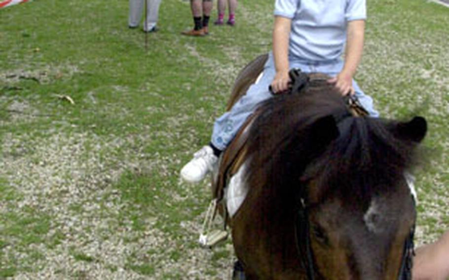 Two-year-old Avery Mills, who recently arrived in Germany recently with her dad, 2nd Cavalry (Stryker) Regiment soldier Capt. Eddie Mills, rides a pony at a Youth 2 Youth kids’ festival in Sorghof, Germany, on Saturday.