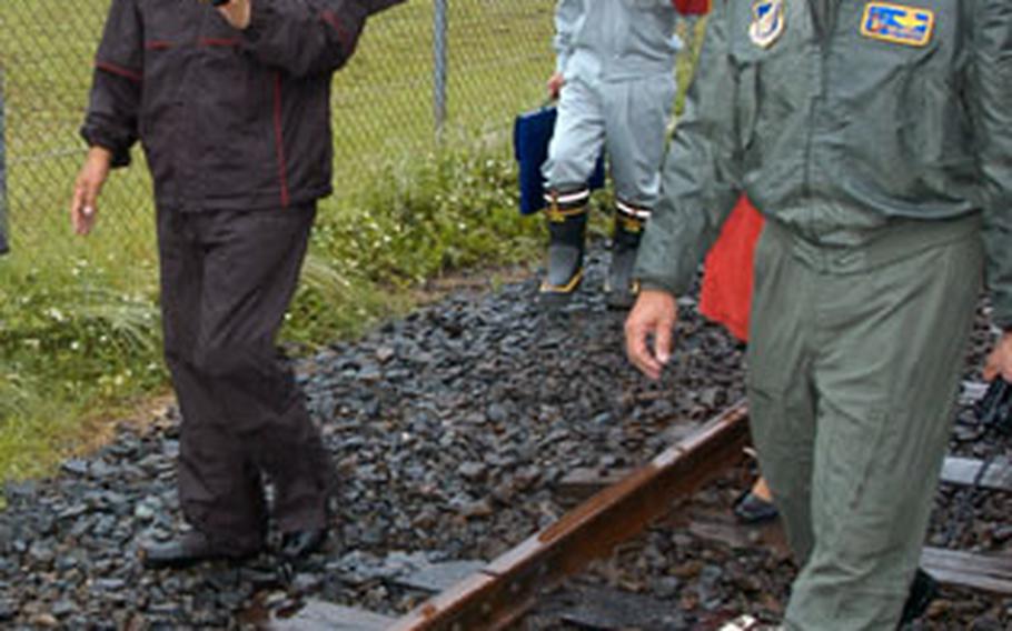 Misawa City Mayor Shigeyoshi Suzuki, left, walks with 35th Fighter Wing Commander Brig. Gen. Sam Angelella last week along railroad tracks that skirt the main Misawa Air Base and the new American Village being built in Misawa city. The local leaders discussed what to do with the area once the tracks are pulled sometime in late fall.