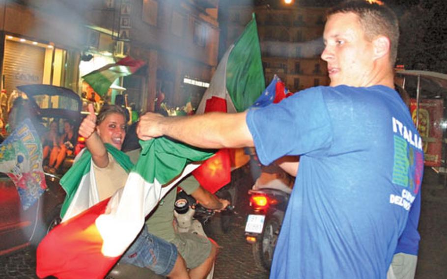 Glenn Robertson waves an Italian flag and cheers to passing motorists celebrating into the early morning hours Monday after Italy’s victory over France in the 2006 World Cup final.