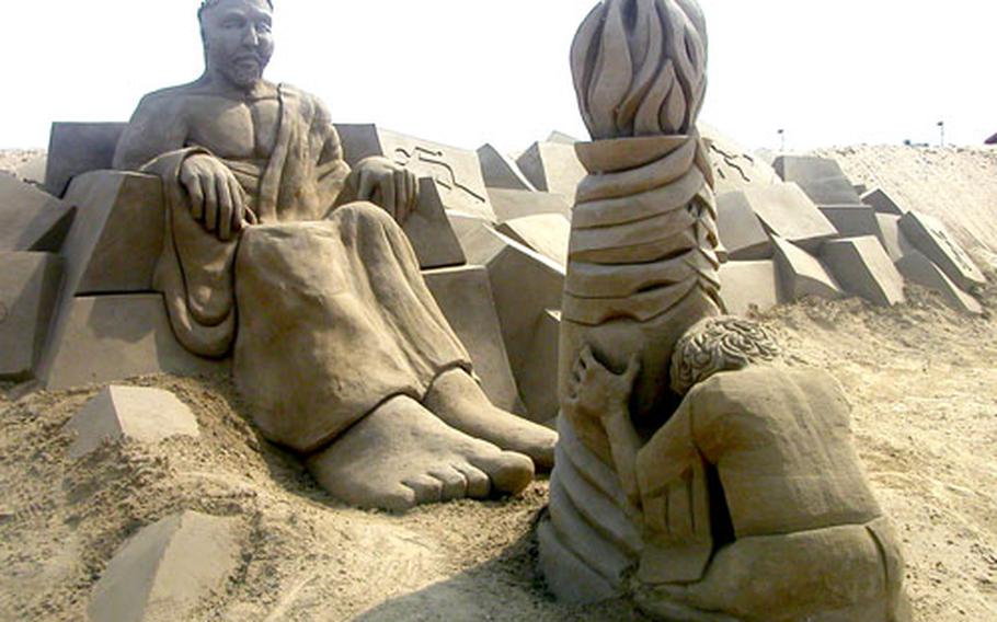 A sand sculpture depicts a woman paying homage to a powerful man clad in a toga at the Great Yarmouth sand sculpting festival.
